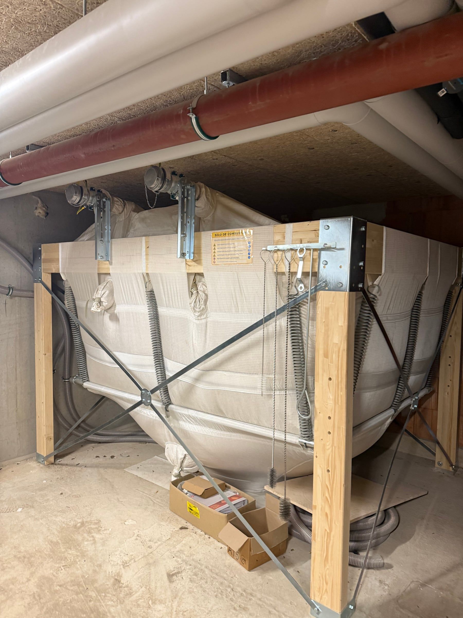 Silo textile de stockage des granulés de bois sur structure en bois, avec ses vis d’alimentation